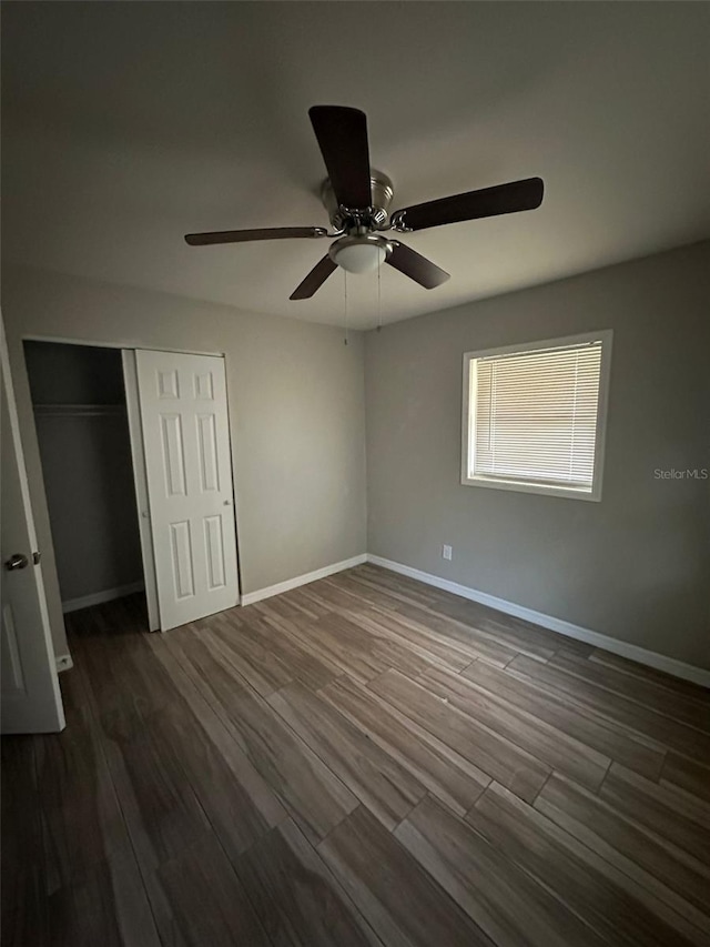 unfurnished bedroom with a closet, ceiling fan, and dark hardwood / wood-style flooring