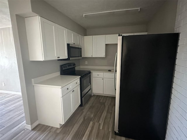 kitchen with dark hardwood / wood-style floors, white cabinetry, and stainless steel appliances