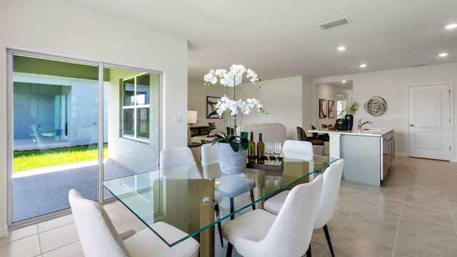 dining room with a wealth of natural light, sink, and light tile patterned floors