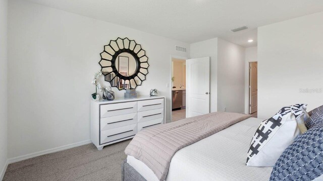 bedroom with light carpet and connected bathroom