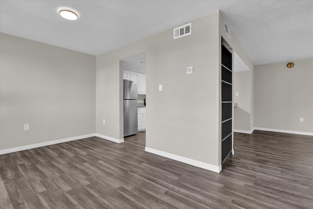 empty room with dark hardwood / wood-style flooring