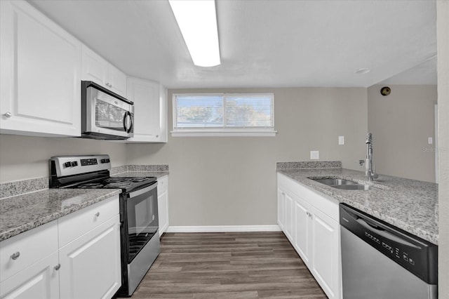 kitchen featuring sink, light stone countertops, dark hardwood / wood-style flooring, white cabinetry, and stainless steel appliances