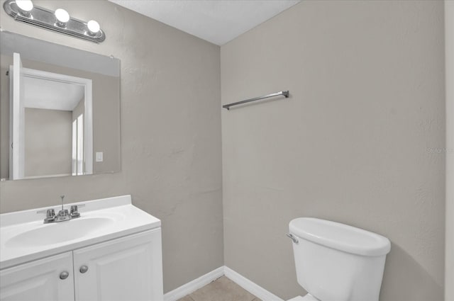 bathroom with tile patterned flooring, vanity, and toilet