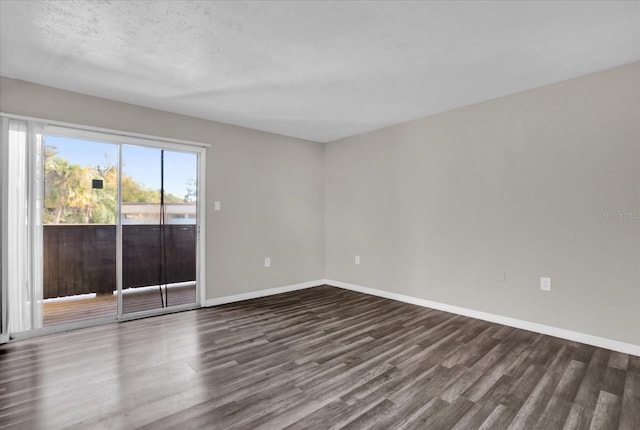 empty room featuring dark wood-type flooring and a textured ceiling