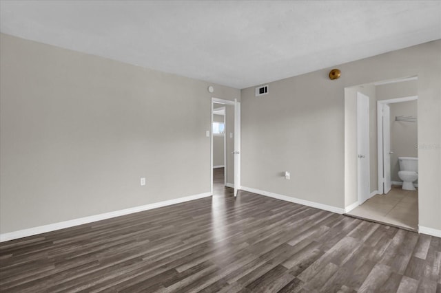 empty room with dark hardwood / wood-style flooring