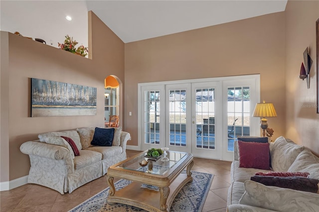 living room featuring light tile patterned floors, high vaulted ceiling, and french doors