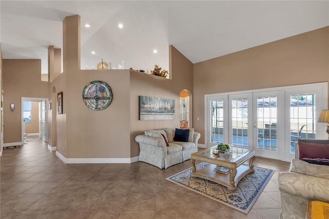 tiled living room with high vaulted ceiling and french doors