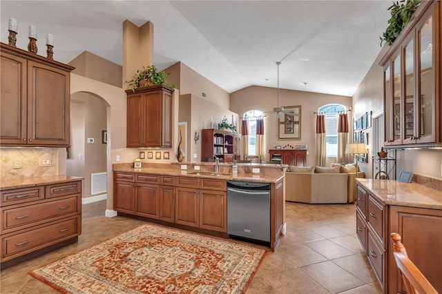 kitchen with vaulted ceiling, sink, light tile patterned floors, decorative light fixtures, and dishwasher