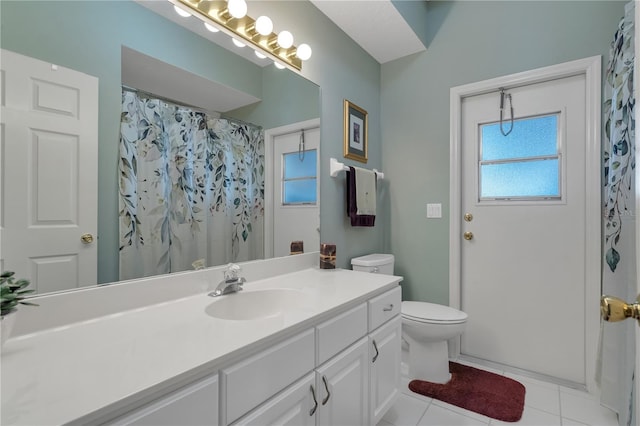 bathroom with tile patterned flooring, vanity, toilet, and walk in shower