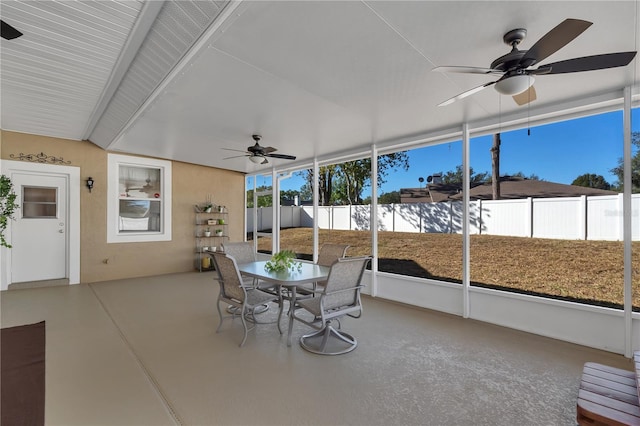 unfurnished sunroom with beam ceiling, a wealth of natural light, and ceiling fan