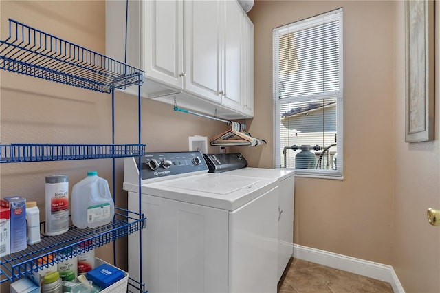 laundry area with separate washer and dryer, light tile patterned floors, and cabinets