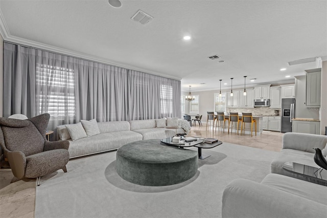 living room featuring crown molding, light tile patterned floors, and a chandelier