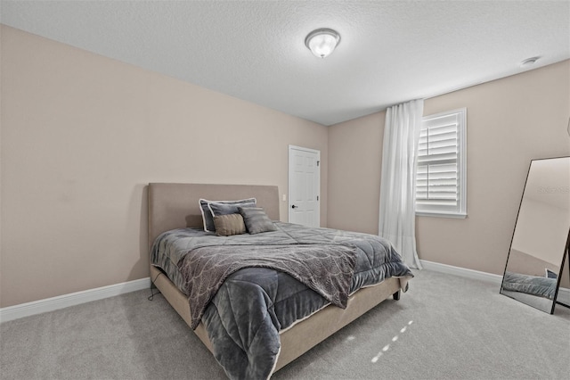 bedroom featuring a textured ceiling and light carpet