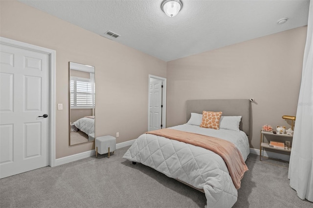 bedroom featuring light carpet and a textured ceiling