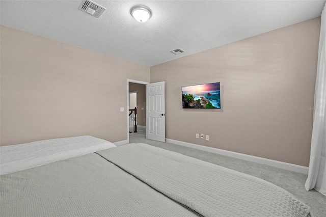 carpeted bedroom featuring a textured ceiling and vaulted ceiling