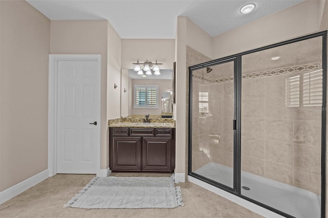 bathroom featuring tile patterned floors, vanity, walk in shower, and a textured ceiling