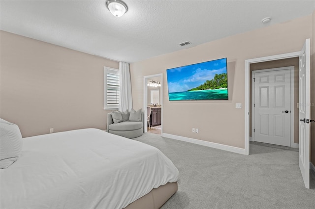 bedroom with light carpet, a textured ceiling, and connected bathroom