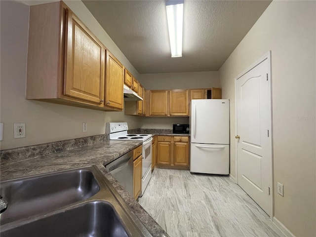 kitchen with sink, stainless steel appliances, a textured ceiling, and light hardwood / wood-style floors