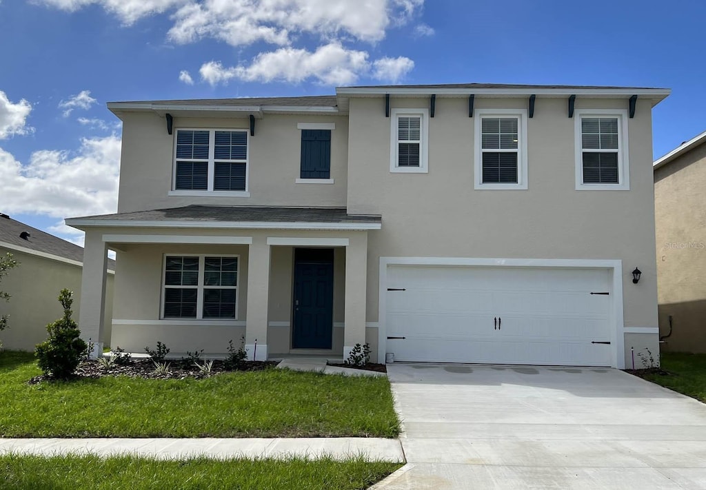 view of front of home with a front yard and a garage