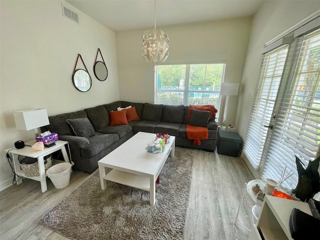 living room featuring light hardwood / wood-style floors and an inviting chandelier