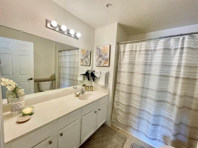 bathroom featuring curtained shower, vanity, a textured ceiling, and toilet