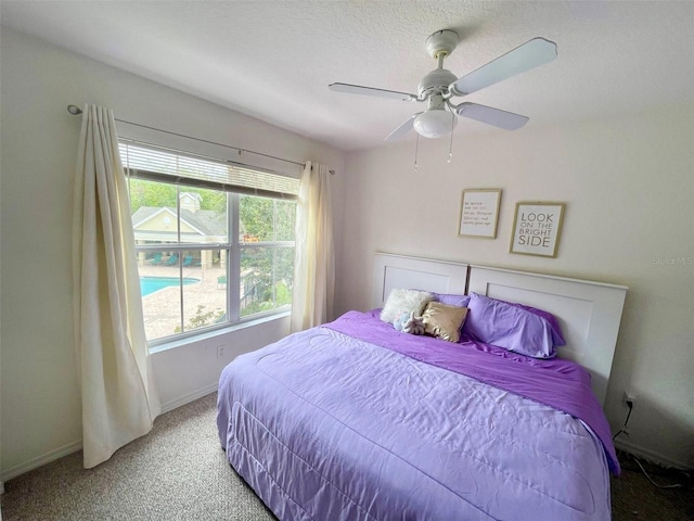 carpeted bedroom with ceiling fan and a textured ceiling