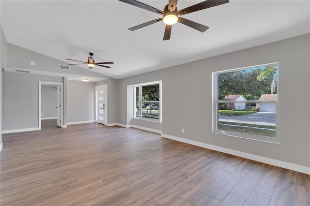 unfurnished living room with ceiling fan, lofted ceiling, and light wood-type flooring