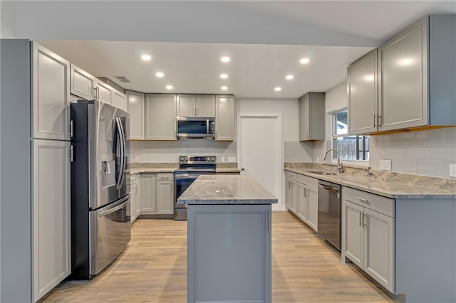 kitchen with gray cabinets, a kitchen island, and appliances with stainless steel finishes