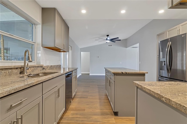 kitchen with lofted ceiling, sink, ceiling fan, light wood-type flooring, and appliances with stainless steel finishes