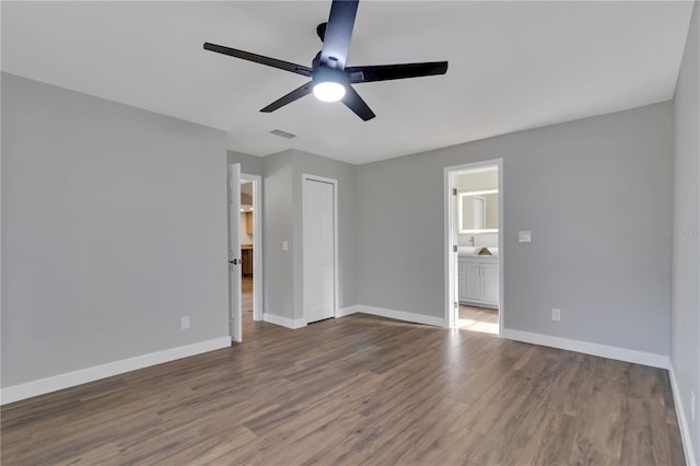 unfurnished bedroom with dark hardwood / wood-style floors, ceiling fan, a closet, and ensuite bath