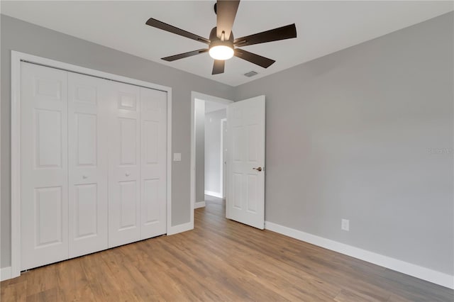 unfurnished bedroom featuring ceiling fan, a closet, and light hardwood / wood-style flooring