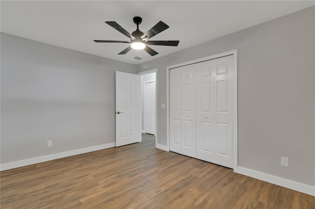 unfurnished bedroom featuring a closet, hardwood / wood-style flooring, and ceiling fan