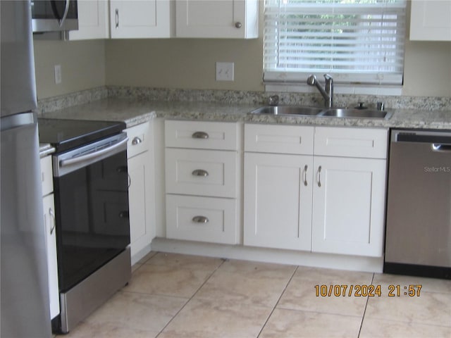 kitchen with sink, white cabinetry, stainless steel appliances, and light tile patterned floors