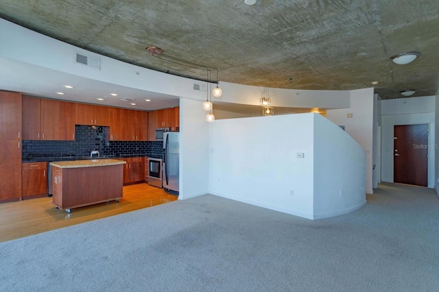 kitchen featuring backsplash, stainless steel appliances, decorative light fixtures, light hardwood / wood-style floors, and a kitchen island