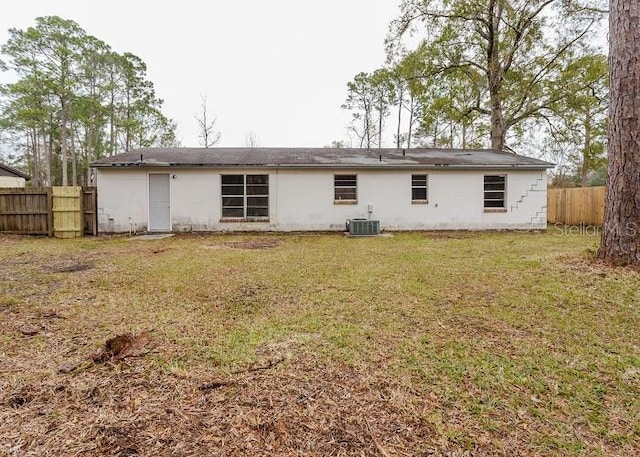 back of property featuring a fenced backyard, a lawn, and central AC unit