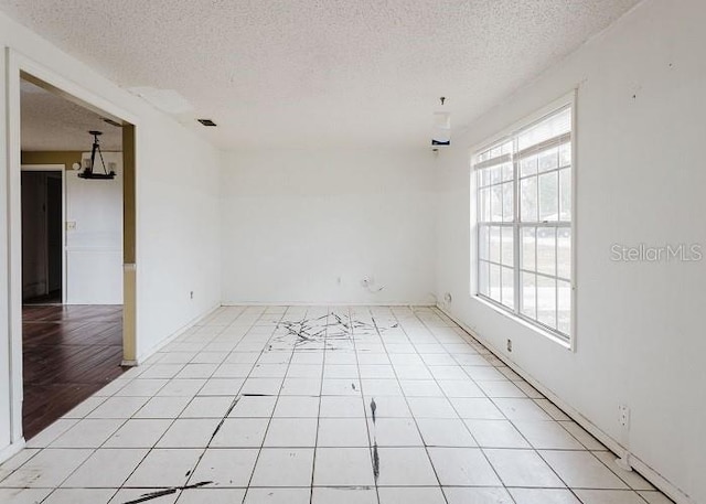 unfurnished room featuring light tile patterned floors and a textured ceiling