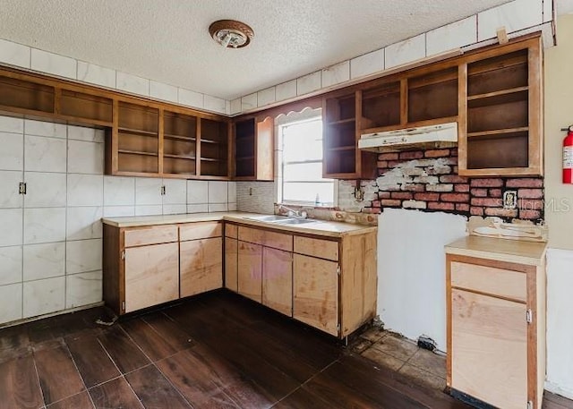 kitchen featuring dark wood-type flooring, light countertops, a textured ceiling, under cabinet range hood, and open shelves