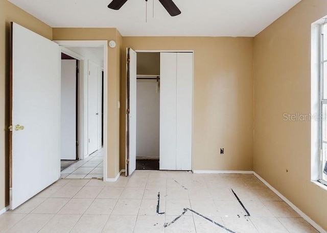 unfurnished bedroom featuring a ceiling fan, a closet, baseboards, and light tile patterned floors