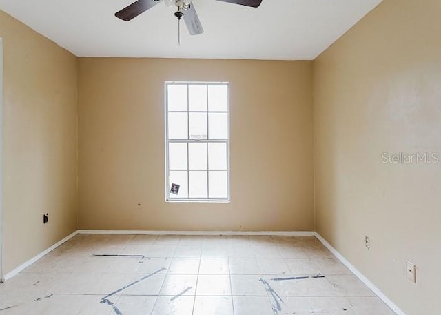 unfurnished room featuring a ceiling fan and baseboards