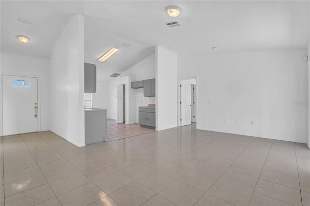 unfurnished living room with lofted ceiling and light tile patterned flooring