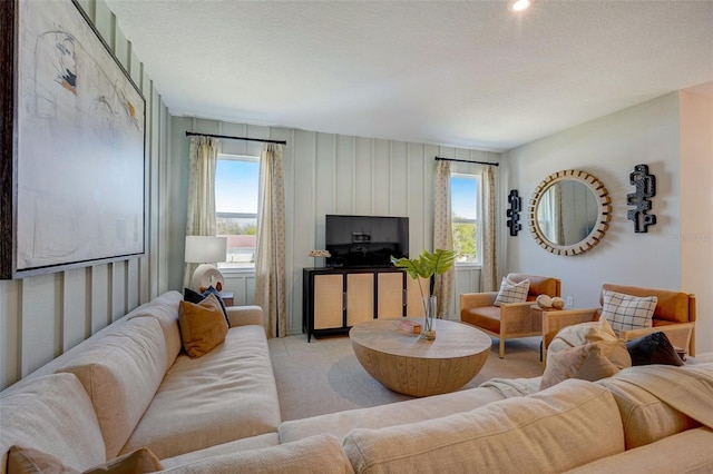 carpeted living room featuring a textured ceiling