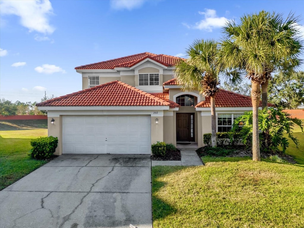 mediterranean / spanish-style home featuring a front lawn and a garage