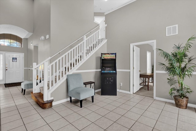 tiled entryway featuring a towering ceiling