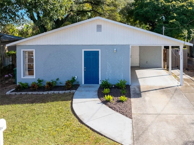 ranch-style house featuring a front yard and a carport