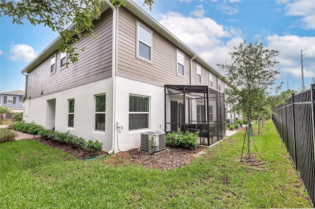 back of property featuring a yard and central AC