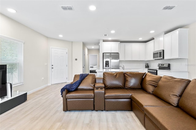 living room featuring light wood-type flooring and sink