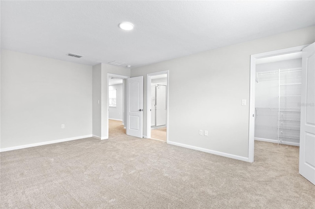 unfurnished bedroom with light carpet and a closet