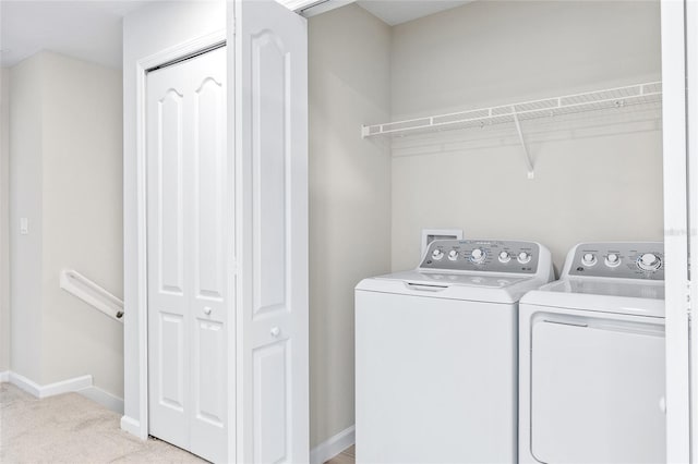 clothes washing area featuring separate washer and dryer and light carpet