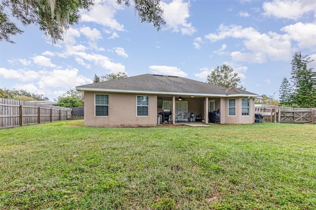 rear view of house with a yard, a patio, and ceiling fan