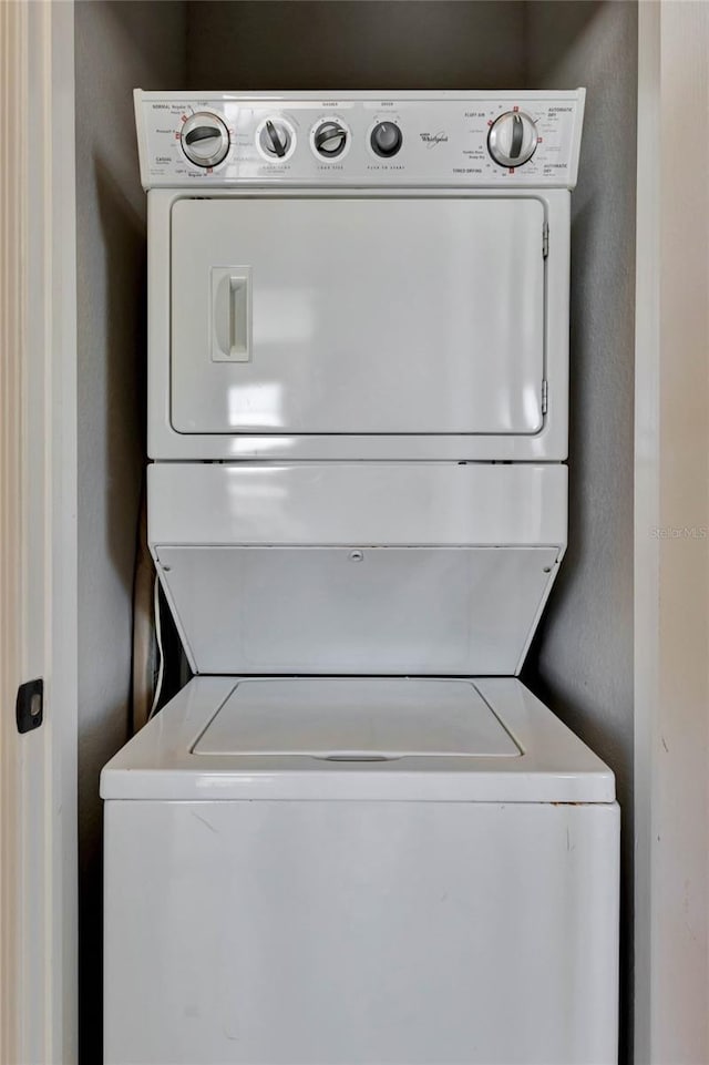 clothes washing area featuring stacked washer and dryer